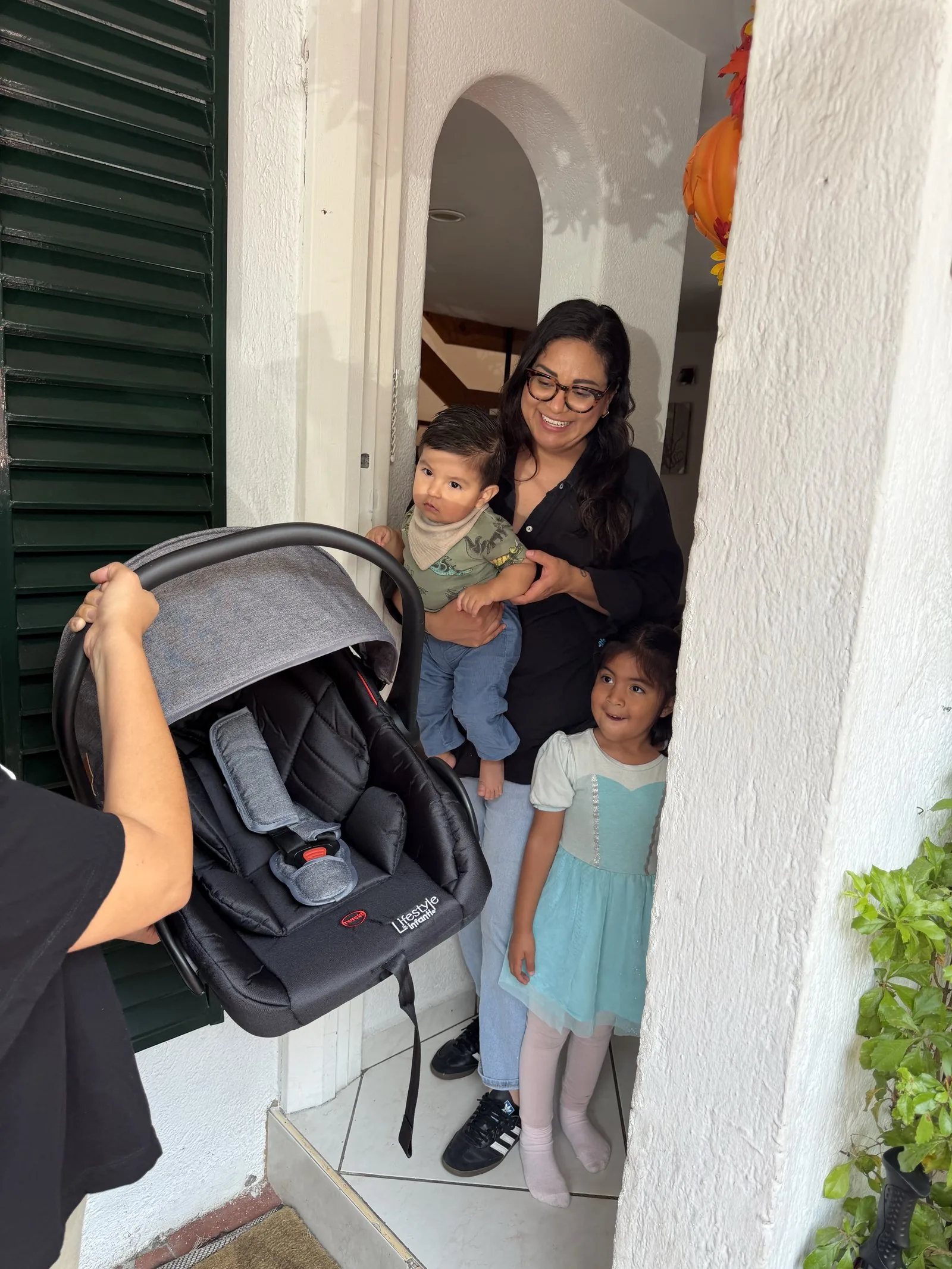 Entrega de una silla de auto a una familia en la puerta de su alojamiento