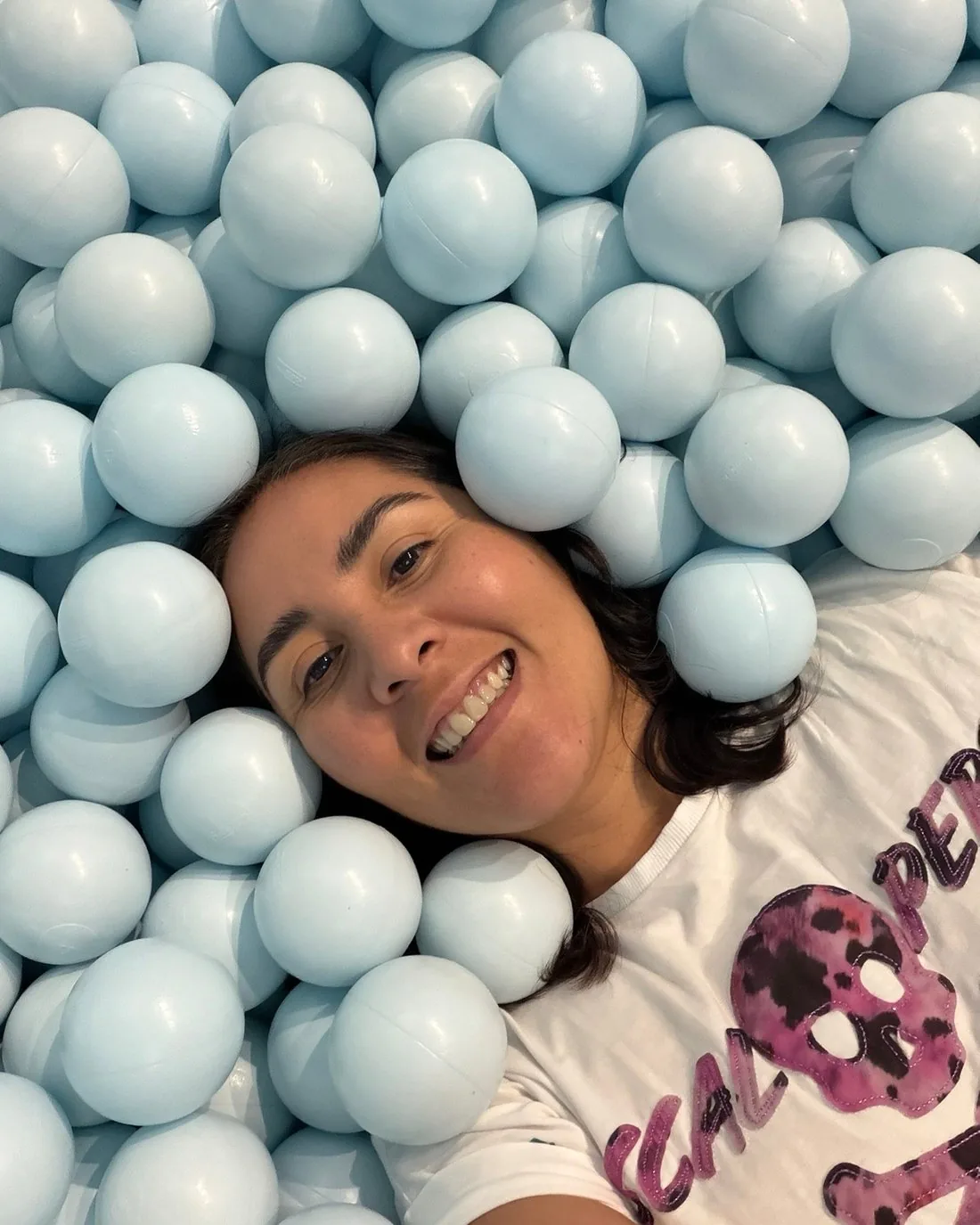 Lilian, fundadora de The Nomad Baby, recostada entre pelotas de una alberca infantil